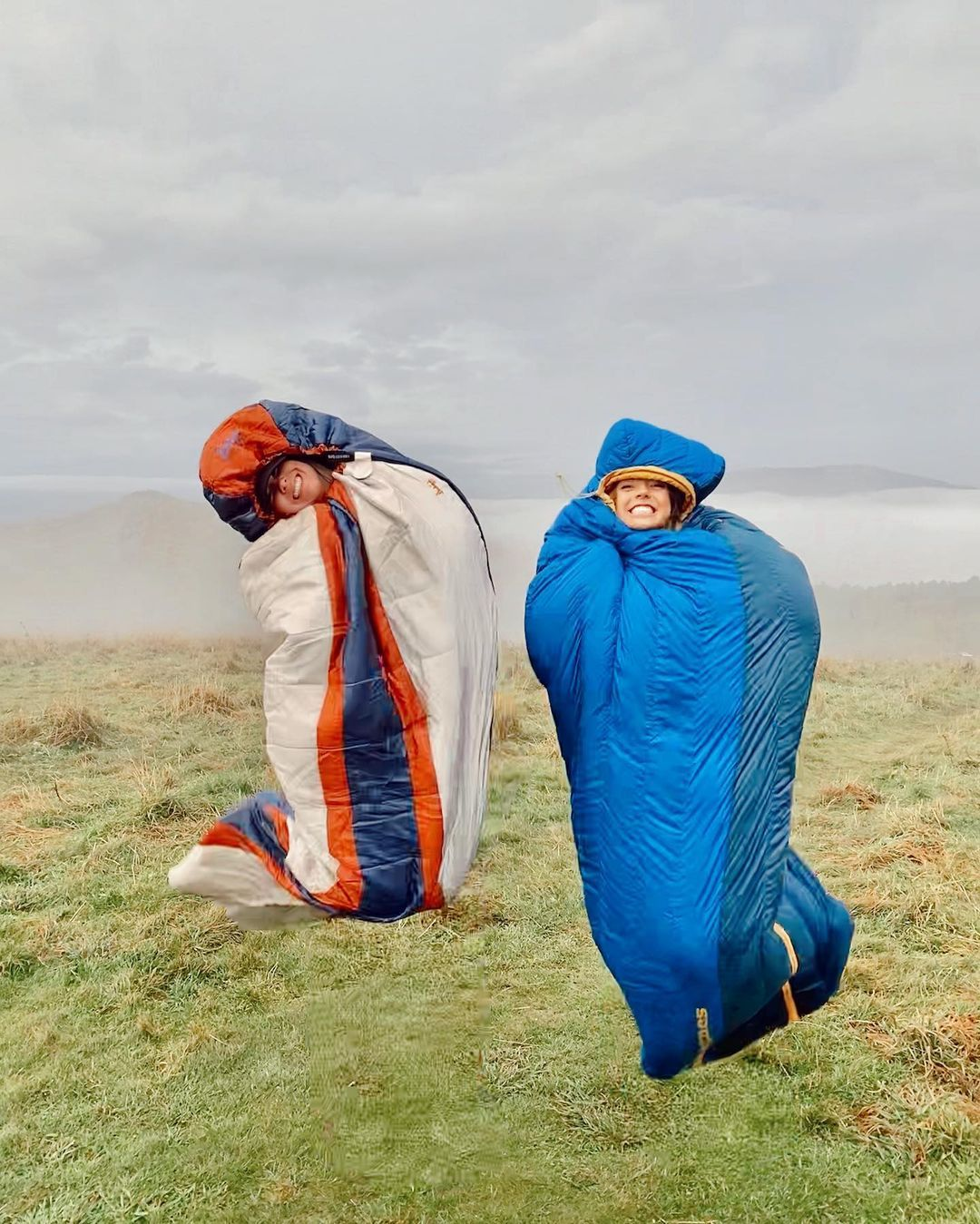 Two people in sleeping bags outdoors